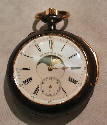 This watch was brought in by a member of the public for appraisal - it was not displayed in the exhibition.
The main dial shows the phases iof the moon. In the back is a calendar dial.
Housed in a Swiss gunmetal (Black steel) case with gold mountings.